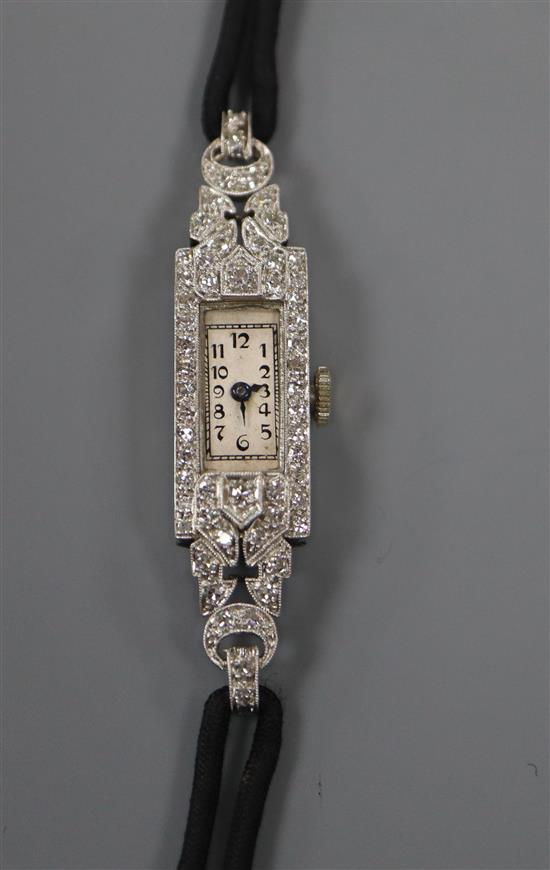 A ladys mid 20th century white metal (inscribed All Plat) and diamond set cocktail watch, on fabric strap.